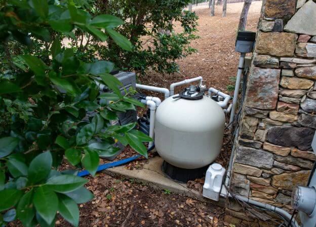 photo d'une pompe de filtration pour piscine dans un jardin