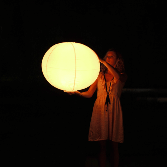 Photo d'une femme portant une Sphère lumineuse platoon air pour la mise en valeur de votre piscine